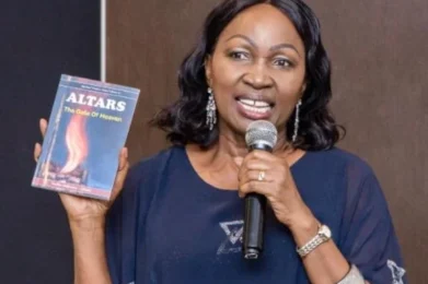 Pastor Nellie poses with her new book on prayer altars